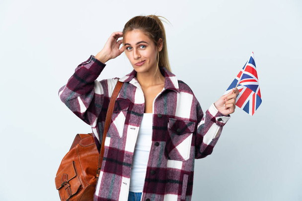 白い背景に英国国旗を掲げた若い女性が疑問を抱いている - 写真・画像