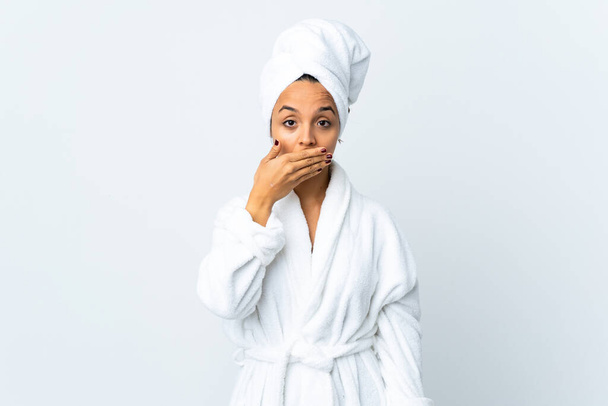 fiatal nő fürdőköpenyben izolált fehér háttér borító száj kézzel - Fotó, kép