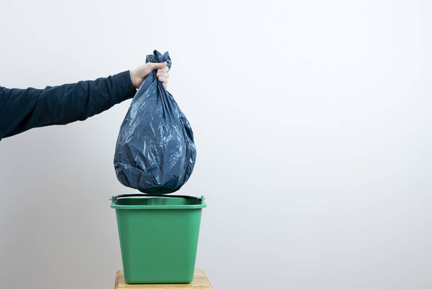 ένα άτομο χέρι ρίχνουν σκουπίδια στον κάδο απορριμμάτων - Φωτογραφία, εικόνα