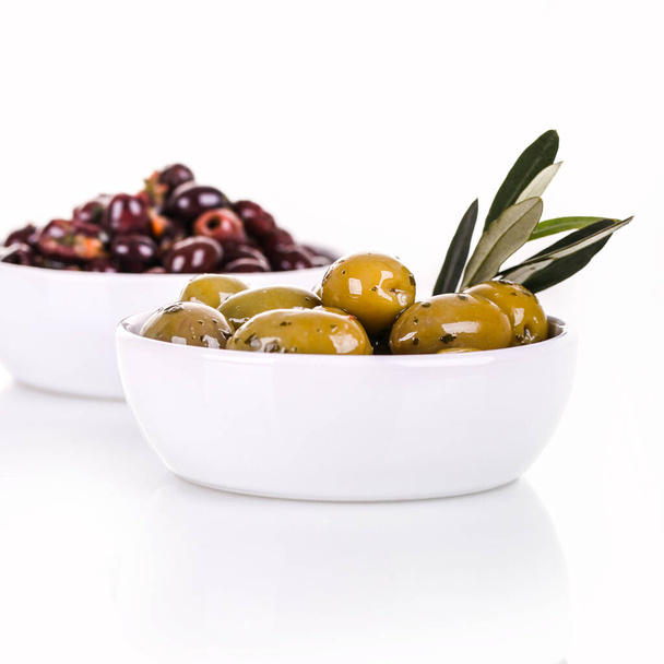 White ceramic bowls of green and black olives, isolated over a white background, with space for text.  - Photo, Image