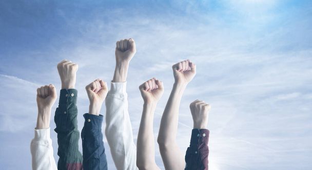 手を挙げた人々は平等への抗議の象徴として空中で拳を挙げます。自由. - 写真・画像
