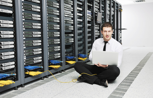 Young handsome business man in black suit practice yoga and relax at network server room while representing stress control concept - Фото, зображення