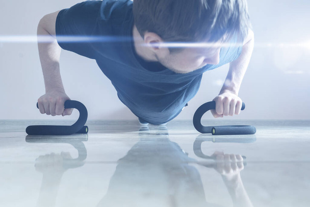 egy férfi személy fekvőtámaszt csinál a padlón, hogy a test fitt, egészséges excersize - Fotó, kép