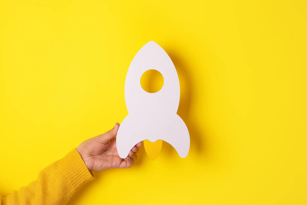 Start up concept with rocket in hand over yellow background, investment, success ideas - Fotografie, Obrázek