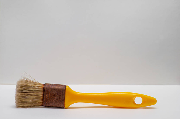 old yellow paint brush on white background with room for text , - Foto, immagini