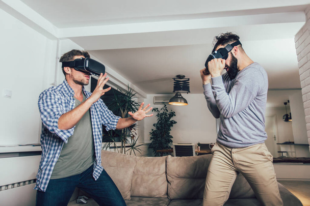 Happy friends playing video games with virtual reality glasses  - Photo, image