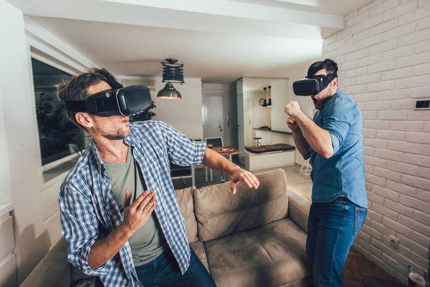 Des amis heureux jouant à des jeux vidéo avec des lunettes de réalité virtuelle  - Photo, image