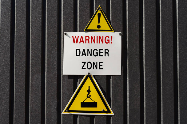 Veszélyzóna figyelmeztetés háromszög jelekkel Figyelmeztetés a rakomány csökkenésének veszélyére. Veszélyzóna figyelmeztető táblák az építkezésen - Fotó, kép
