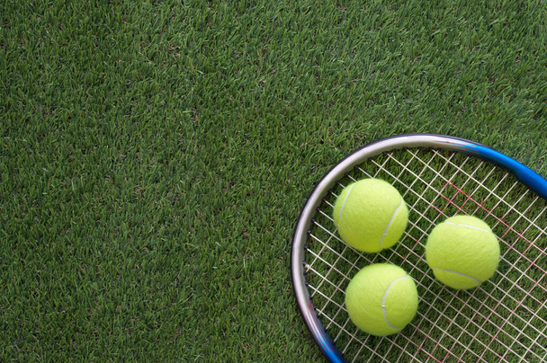 Tennis racket with balls on grass court - Fotoğraf, Görsel