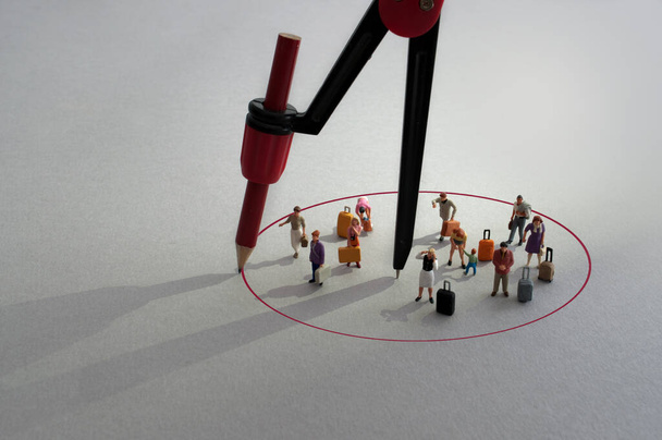 Bussola con cerchio a matita rossa intorno a viaggiatori in miniatura con bagagli - Foto, immagini
