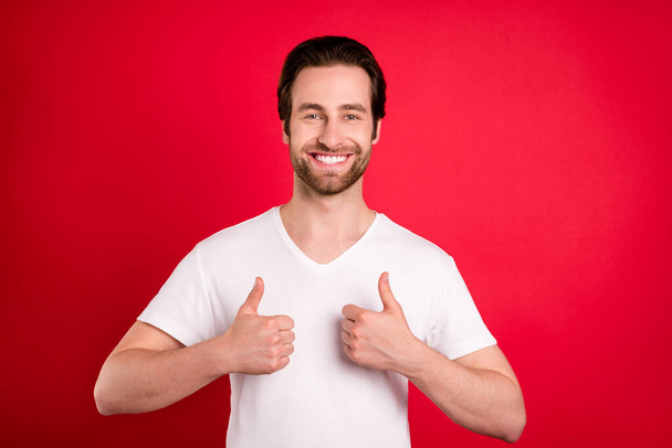 Photo of charming positive happy young man show thumbs up smile good mood isolated on red color background - Foto, imagen