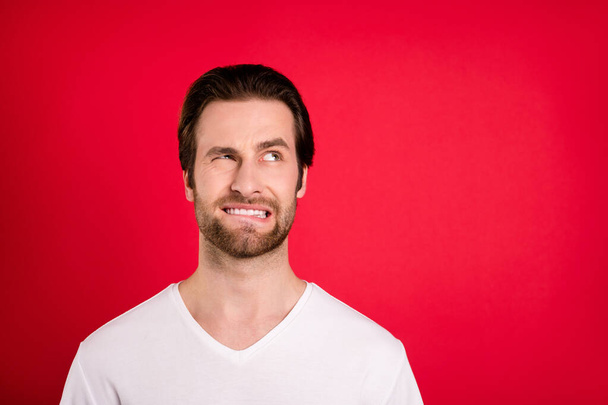 Photo of unhappy upset young man look empty space problem bad mood isolated on red color background - Fotoğraf, Görsel