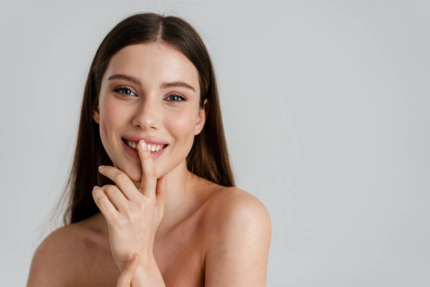 Happy shirtless girl smiling and showing silence gesture isolated over white background - Foto, Imagem