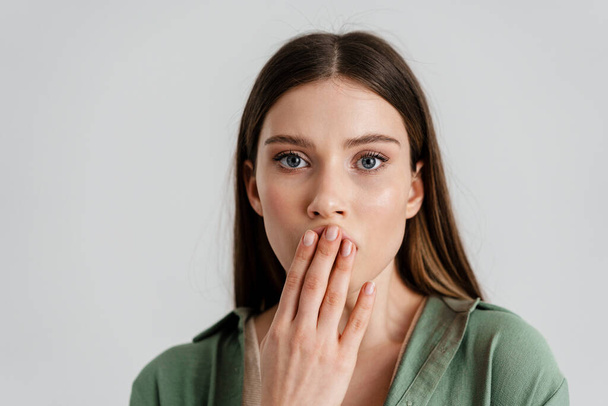 Surprised caucasian girl covering her mouth and looking at camera isolated over white background - Foto, immagini