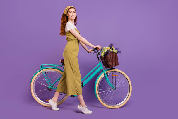 Full length body size profile side view of pretty cheerful girl walking cycle isolated over violet purple color background - Photo, image