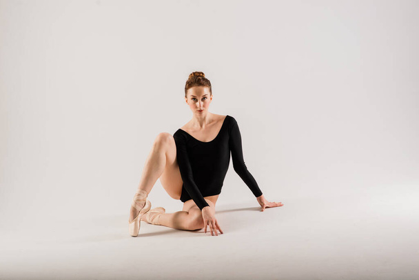 Portarit of Sensual professional caucan callet dancer in body suit and pointes shoes. - Фото, изображение