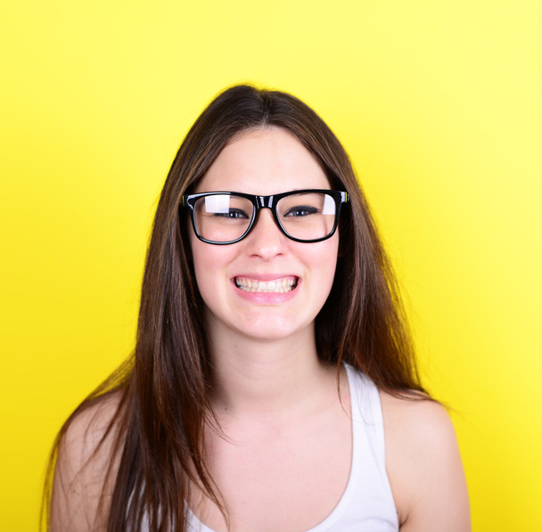 Portrait of happy casual woman with glasses against yellow backg - Фото, изображение