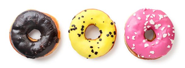 Drie veelkleurige donuts close-up op een witte achtergrond. Bovenaanzicht. - Foto, afbeelding