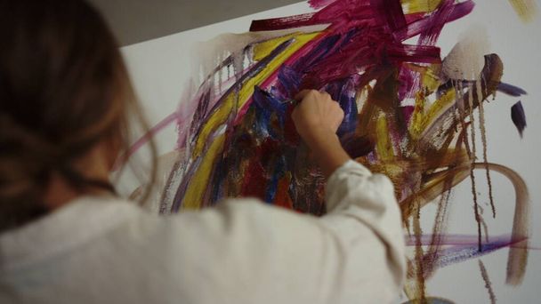 Mujer inspirada pintando en el estudio. Talentoso pintor creando sobre lienzo en interiores. - Foto, imagen