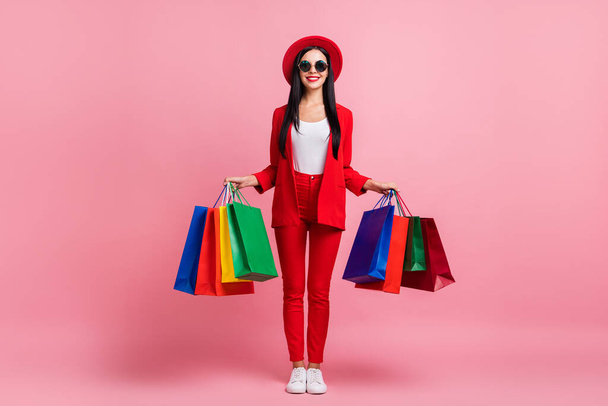 Full length photo of young girl happy positive smile hold bags shopping sale isolated over pink color background - 写真・画像