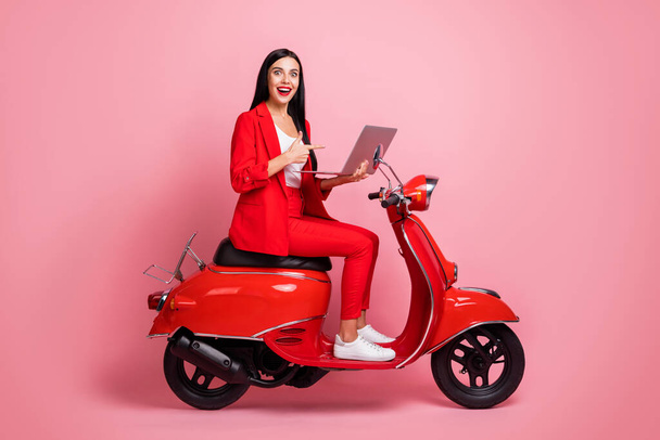Full body profile side photo of young girl indicate finger laptop promo select suggest sit scooter isolated over pink color background - Φωτογραφία, εικόνα