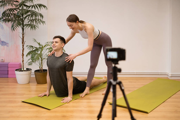Man en vrouw die online yoga lessen geven - Foto, afbeelding