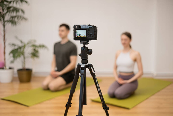 Uomo e donna che insegnano lezioni di yoga online - Foto, immagini