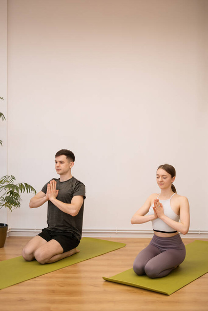 Coppia sportiva praticare yoga insieme a casa - Foto, immagini