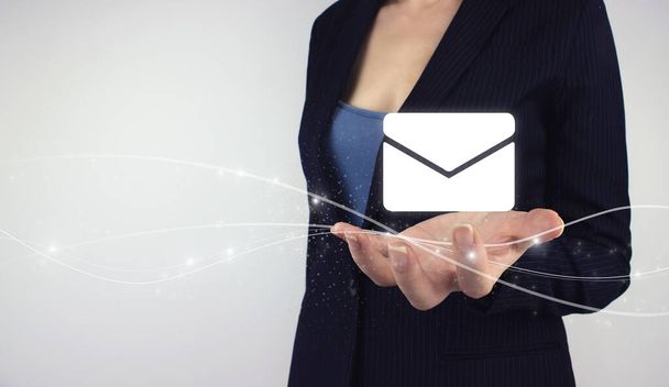 Senden von E-Mail Marketing Konzept. Hand halten digitales Hologramm E-Mail auf grauem Hintergrund - Foto, Bild