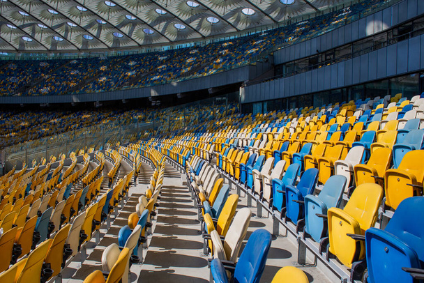 黄色と青のベンチとサッカーオリンピックスタジアムの座席の空の行 - 写真・画像