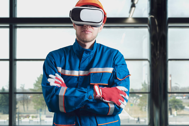 ένας άνδρας εργάτης με στολή που χρησιμοποιεί γυαλιά εικονικής πραγματικότητας, γυαλιά νέας τεχνολογίας - Φωτογραφία, εικόνα