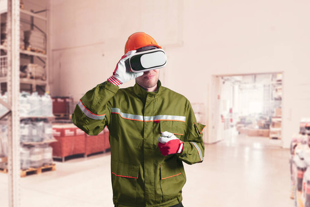 ένας άνδρας εργάτης με στολή που χρησιμοποιεί γυαλιά εικονικής πραγματικότητας, γυαλιά νέας τεχνολογίας - Φωτογραφία, εικόνα