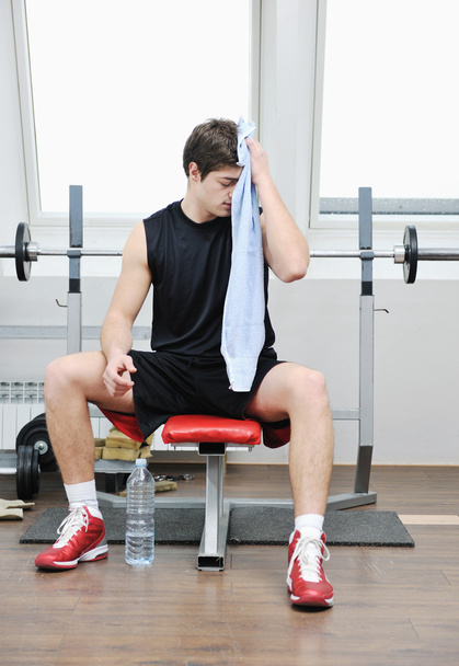 Young man in fintess sport club exercise withweights and relaxing - Фото, зображення