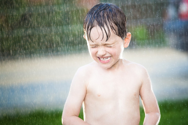маленький хлопчик розважається під час літнього дощу
 - Фото, зображення