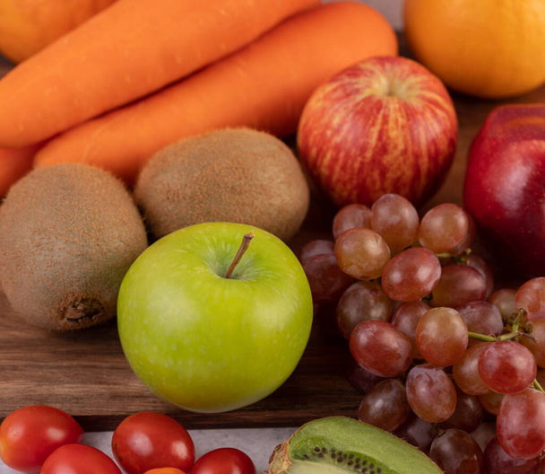 Yere yerleştirilmiş elmalar, üzümler, havuçlar ve portakallar.. - Fotoğraf, Görsel