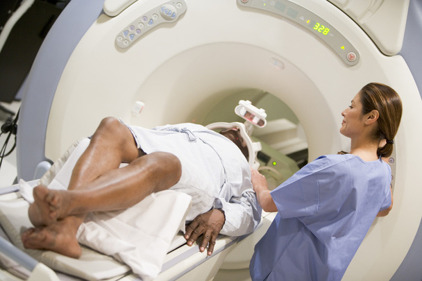 Nurse With Patient As They Prepare For A Computerized Axial Tomography (CAT) Scan - Foto, Bild