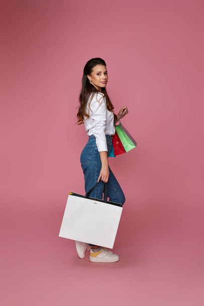 beautiful woman holding shopping bags with purchases - Фото, изображение