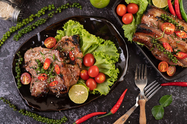Krájený vepřový steak s bílým sezamem a čerstvými paprikovými semínky a rajčaty, citróny, chilli a salátem. - Fotografie, Obrázek