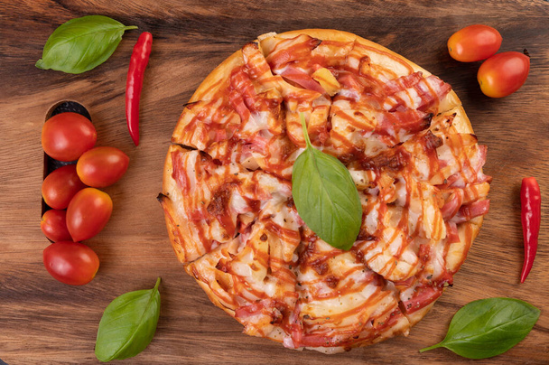Pizza dans un plateau en bois avec tomates Chili et basilic. - Photo, image