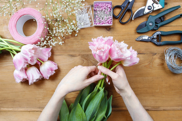 Florist at work. Woman making beautiful bouquet of pink tulips - Fotografie, Obrázek