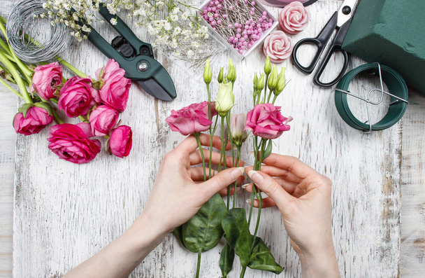 Florist at work. Woman making beautiful bouquet of pink eustoma  - Foto, imagen