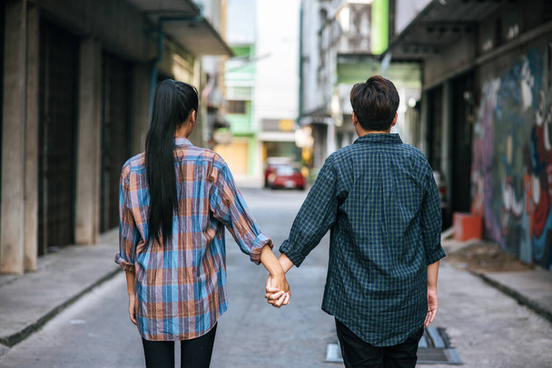 Дві люблячі жінки стоять і тримаються за руки на вулиці
. - Фото, зображення