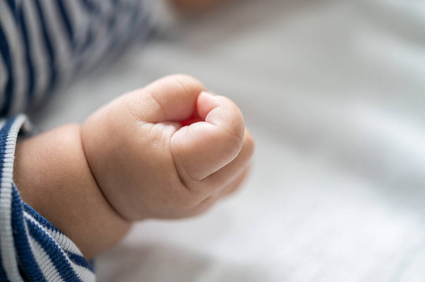 Newborn baby hand in white bed. Selective focus. - Фото, зображення
