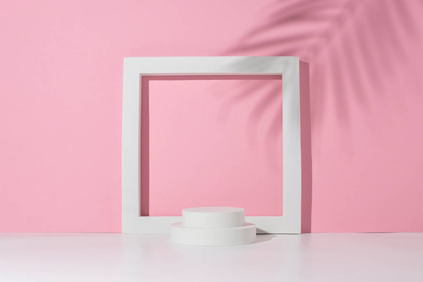 Подиум белый квадрат, круги для представления под тенью пальмовых листьев на белом розовом фоне. - Фото, изображение