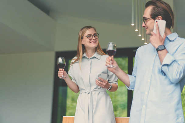 Erfolgreiches Paar hält Gläser mit Rotwein und feiert - Foto, Bild