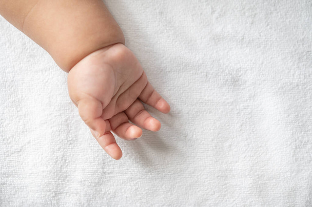 Newborn baby hand in white bed. Selective focus. - Photo, image