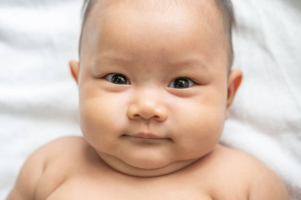 Een pasgeboren baby die zijn ogen opent en vooruit kijkt - Foto, afbeelding