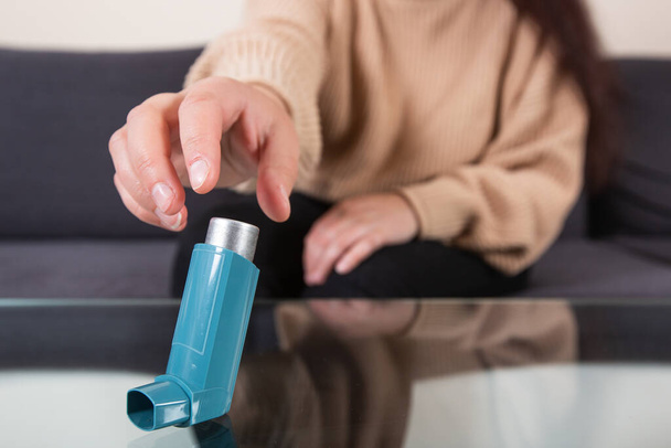 Молодая женщина ищет ингалятор для астмы во время сильного приступа астмы, не может дышать, концепция здравоохранения - Фото, изображение