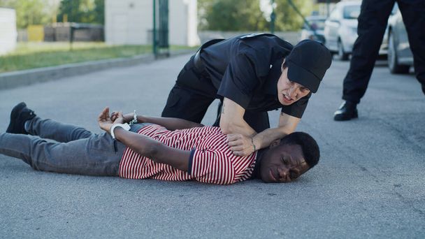 アフリカ系アメリカ人男性を逮捕する多様な警察官 - 写真・画像