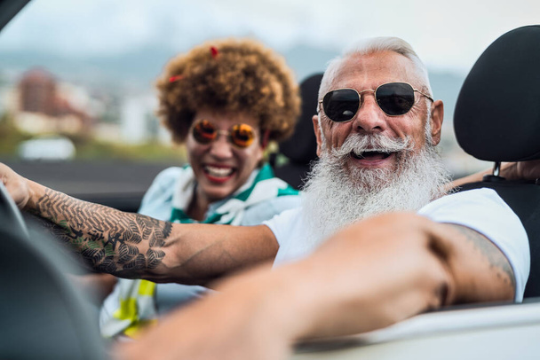 新しいコンバーチブル車で楽しい運転をして幸せな高齢者のカップル-成熟した人々は一緒に道路旅行休暇中に時間を楽しんで-高齢者のライフスタイルと旅行文化の概念 - 写真・画像